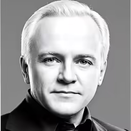 an older gentleman wearing a suit and tie