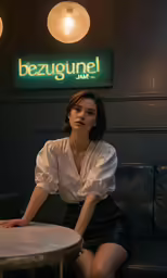a woman in a white shirt and black shorts sitting at a table