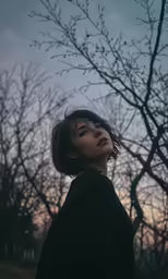 a girl standing in the middle of a tree