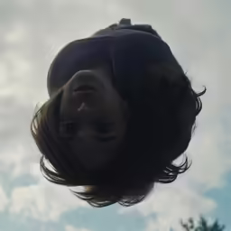 the face and shoulders of a child under a blue cloudy sky