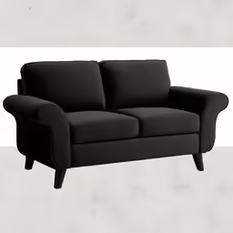 black couch in front of white wall and concrete floor