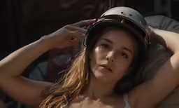 a woman in a helmet is laying down