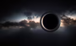 the dark clouds are behind a circular object in the sky