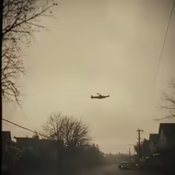 an airplane flying low above a street on a foggy day