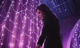 woman in front of purple wall with a net decoration on it