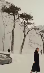 a woman walking across a snow covered field