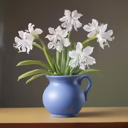 a blue vase filled with white flowers sitting on top of a table