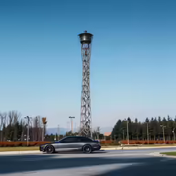 there is a tall street light tower next to this car