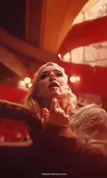 a blond woman is doing something very seductive