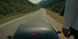 a person riding a motorbike on the road through a mountain