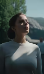 a woman standing next to a tree with her eyes closed
