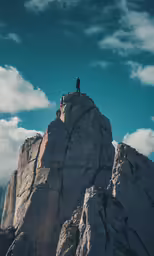 man stands atop of the rocks of mount tim in joshua, ut