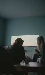 two women having drinks while sitting at a table