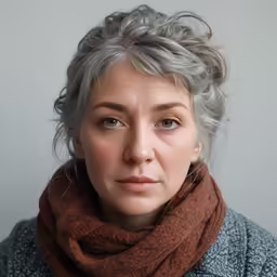 a woman with gray hair is wearing a scarf