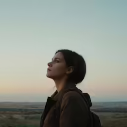 a woman is looking at the sky while standing outside