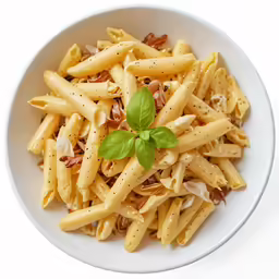 a bowl filled with pasta and topped with a green leaf