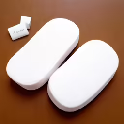 two white pieces of plastic sit next to a white piece
