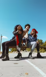 the three women are sitting on the bench together