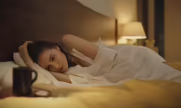 the woman is laying in bed with her eyes closed