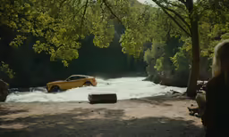there is a yellow car coming out of the river