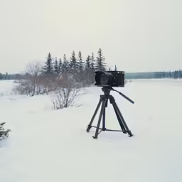 a video camera sits on top of a tripod in the snow