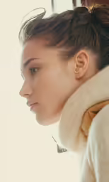 a woman wearing a collar and neck warmer stares down