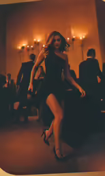 a woman is walking in a long black dress