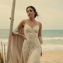 a model walks in a dress by the ocean