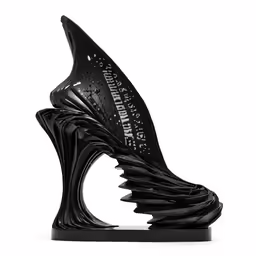 a large sculpture with black color is in the shape of a shoe