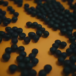 an abstract arrangement of black candies arranged on a orange background