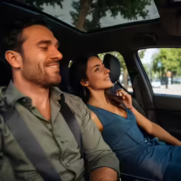 couple sitting in the drivers seat smiling