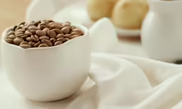 a white bowl filled with lots of brown nuts