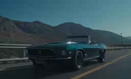 the car is traveling down the road near mountains
