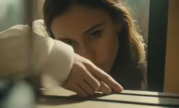 the young woman is leaning her head on the ledge