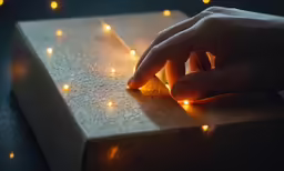 the person is pointing at some lit candles in the dark