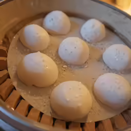 four raw eggs being cooked in a bowl