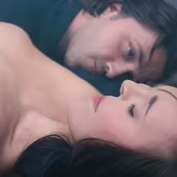 a young couple laying side by side next to each other