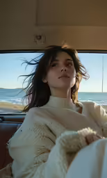 a woman sits in the back seat of a car with a blanket