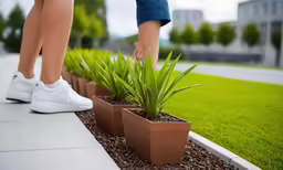 a woman stepping into several planters filled with grass