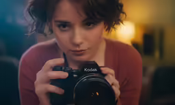 a woman holds up a camera as she takes her photo