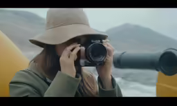 a woman with a hat on taking a photo