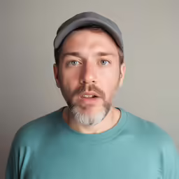 an adult male in a turquoise shirt and hat