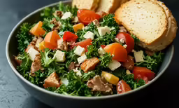 a salad of vegetables, cheese and meat in a bowl