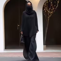 woman walking down the street with a black head covering