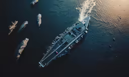 an aerial view of a boat in the water with small ships
