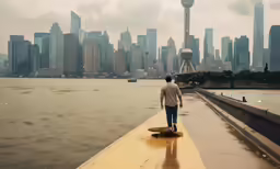 a man walks along a body of water with city in the distance
