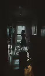 a dark room with a woman standing in the middle of the room