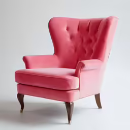 a pink chair with wooden feet and foot rests