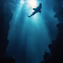 a man scubas through the deep blue water