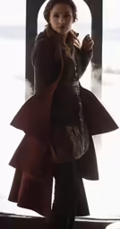 a woman in a coat and tight pants is posing